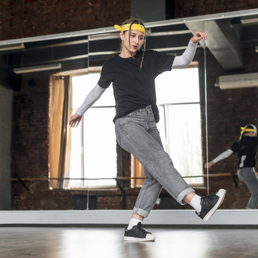 faible-angle-de-vue-de-la-danseuse-dansant-dans-le-studio